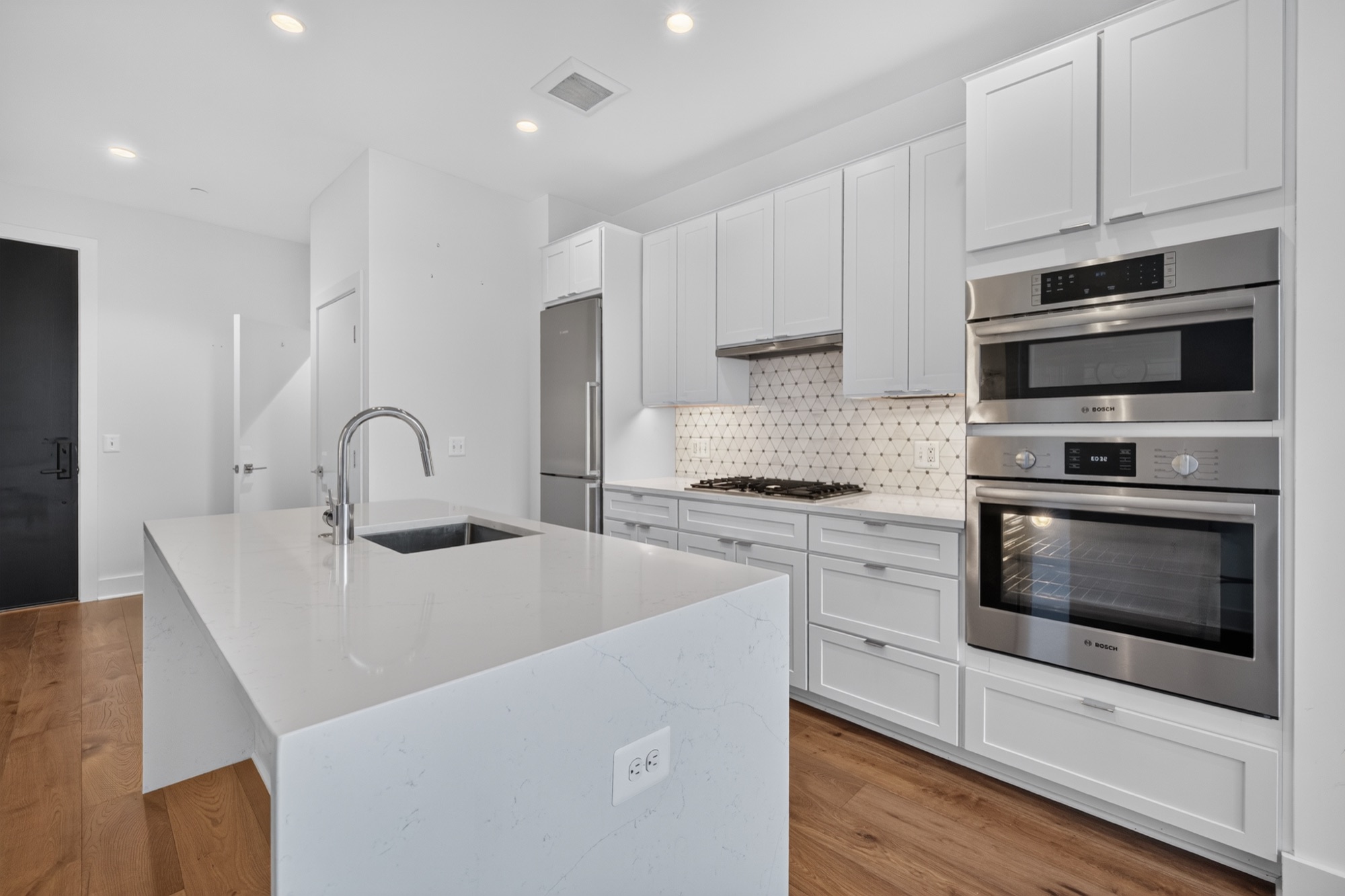 Listing photography — modern white kitchen with waterfall island